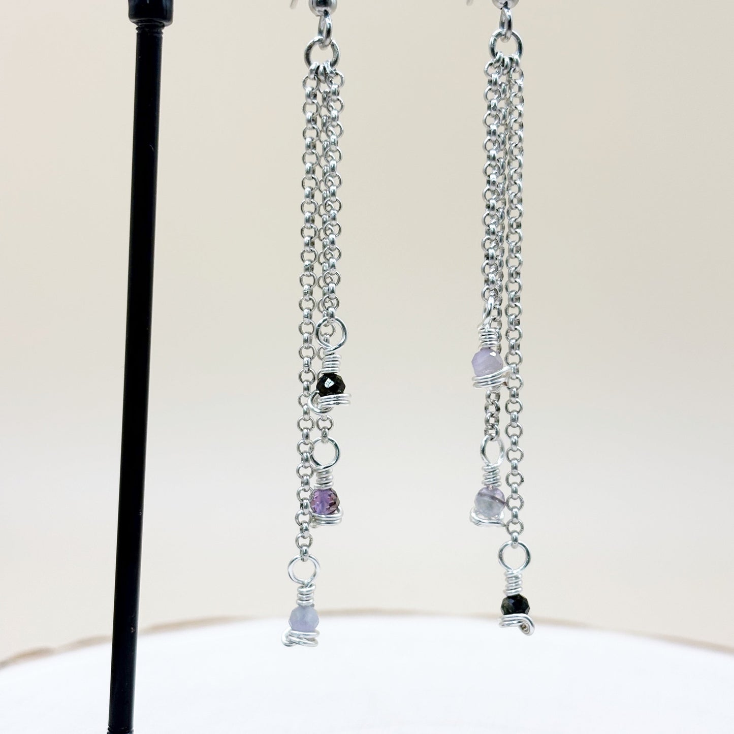Silver chain earrings with small beads on a white background