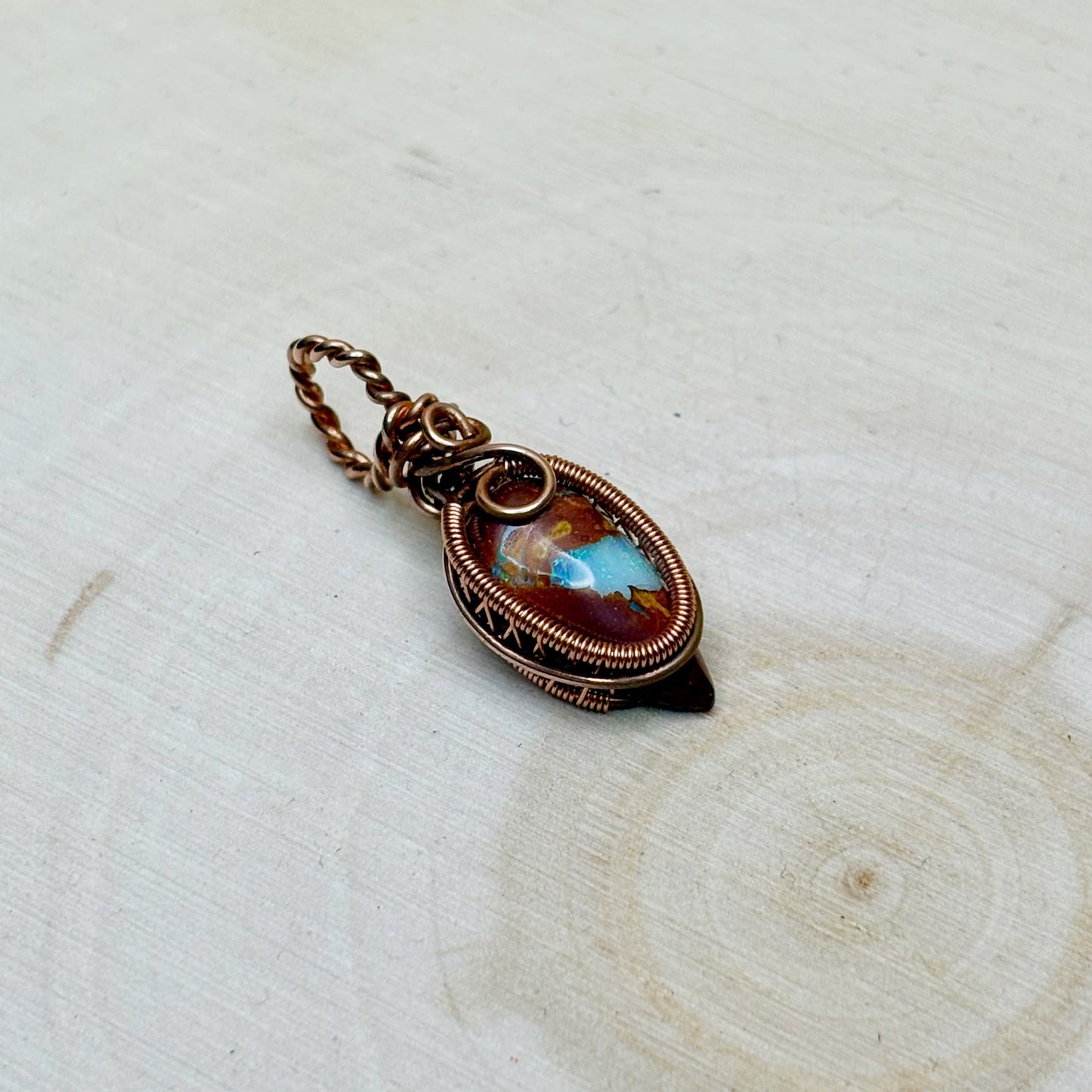 Decorative pendant with a scenic design on a light wooden surface