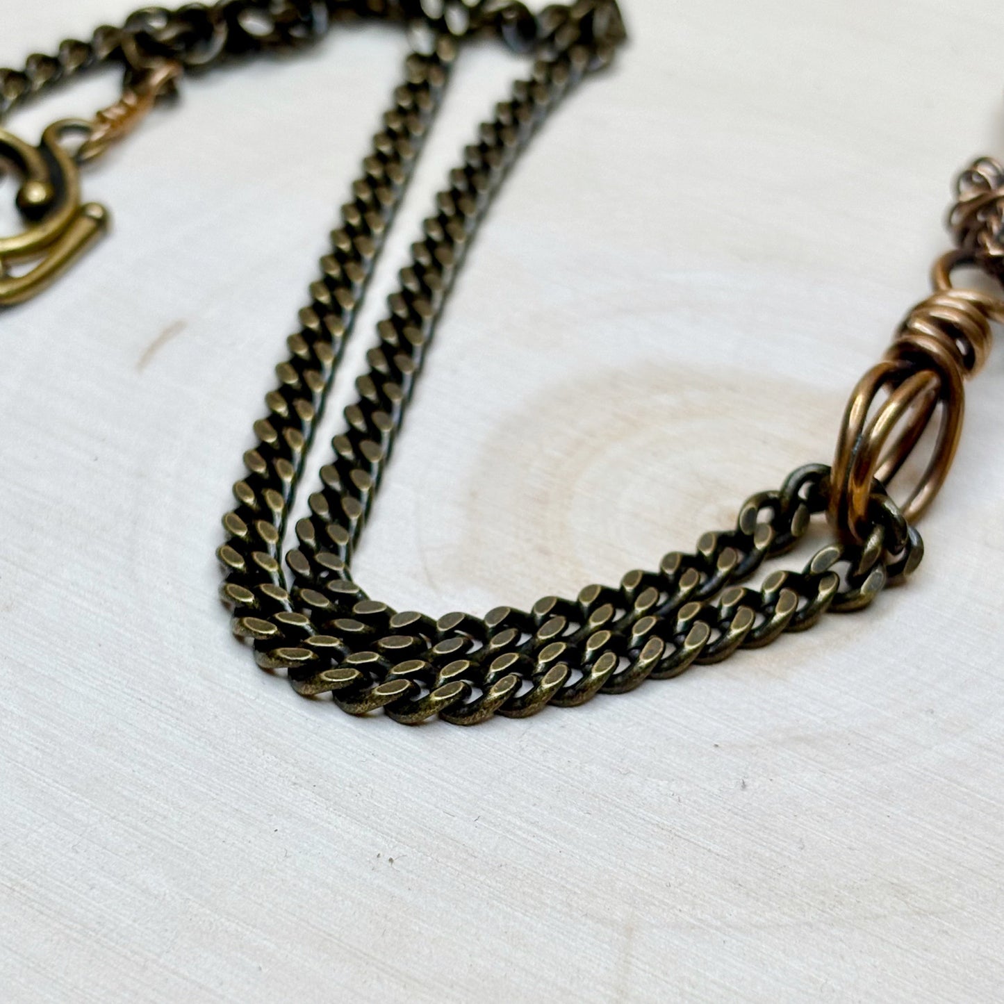 Bronze chain necklace on a white textured surface