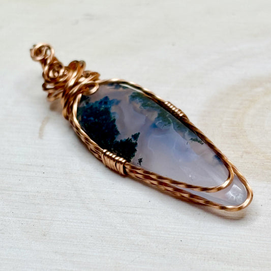 Copper wire wrap moss agate pendant showing purple and green colors