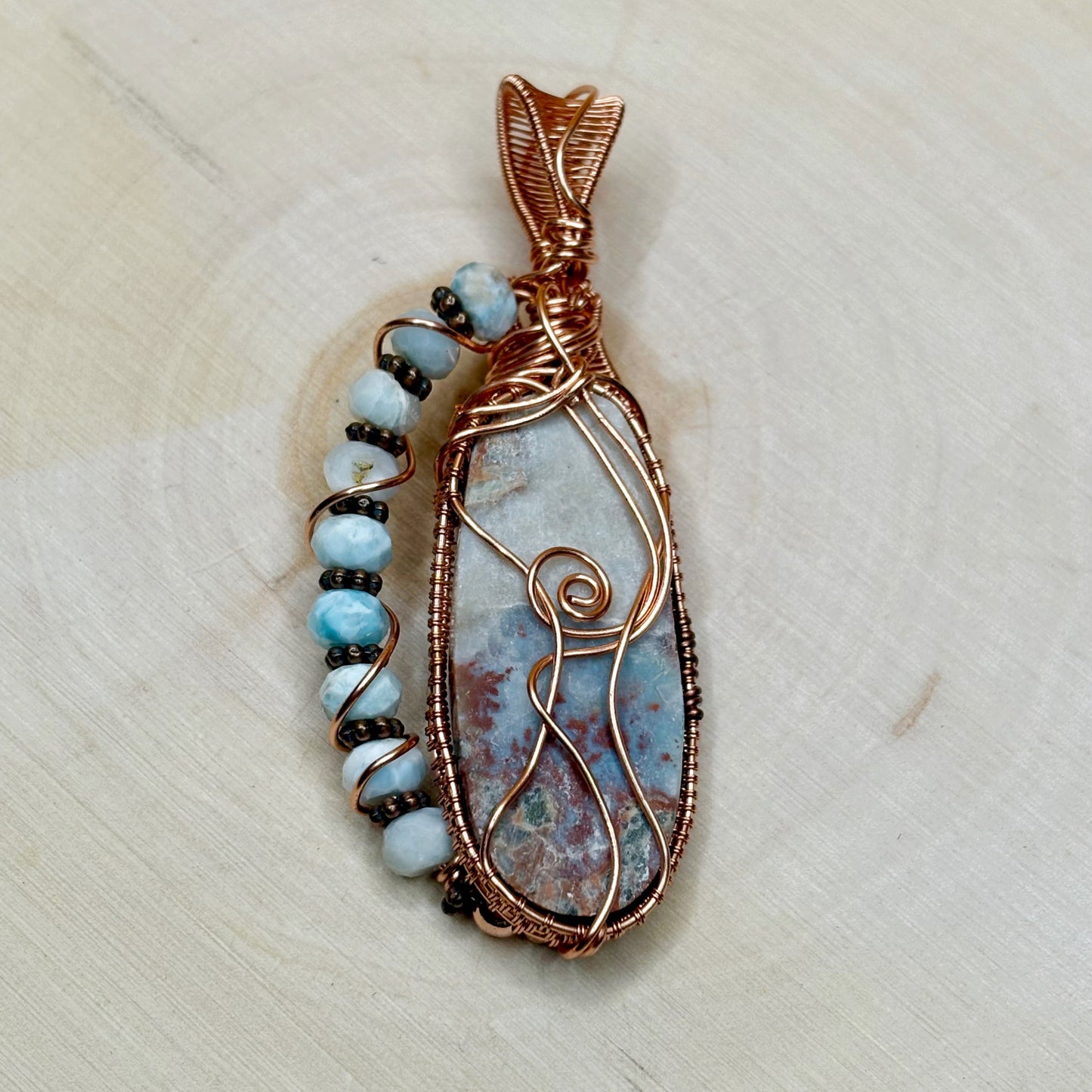 Decorative pendant with stone and beads on a light background
