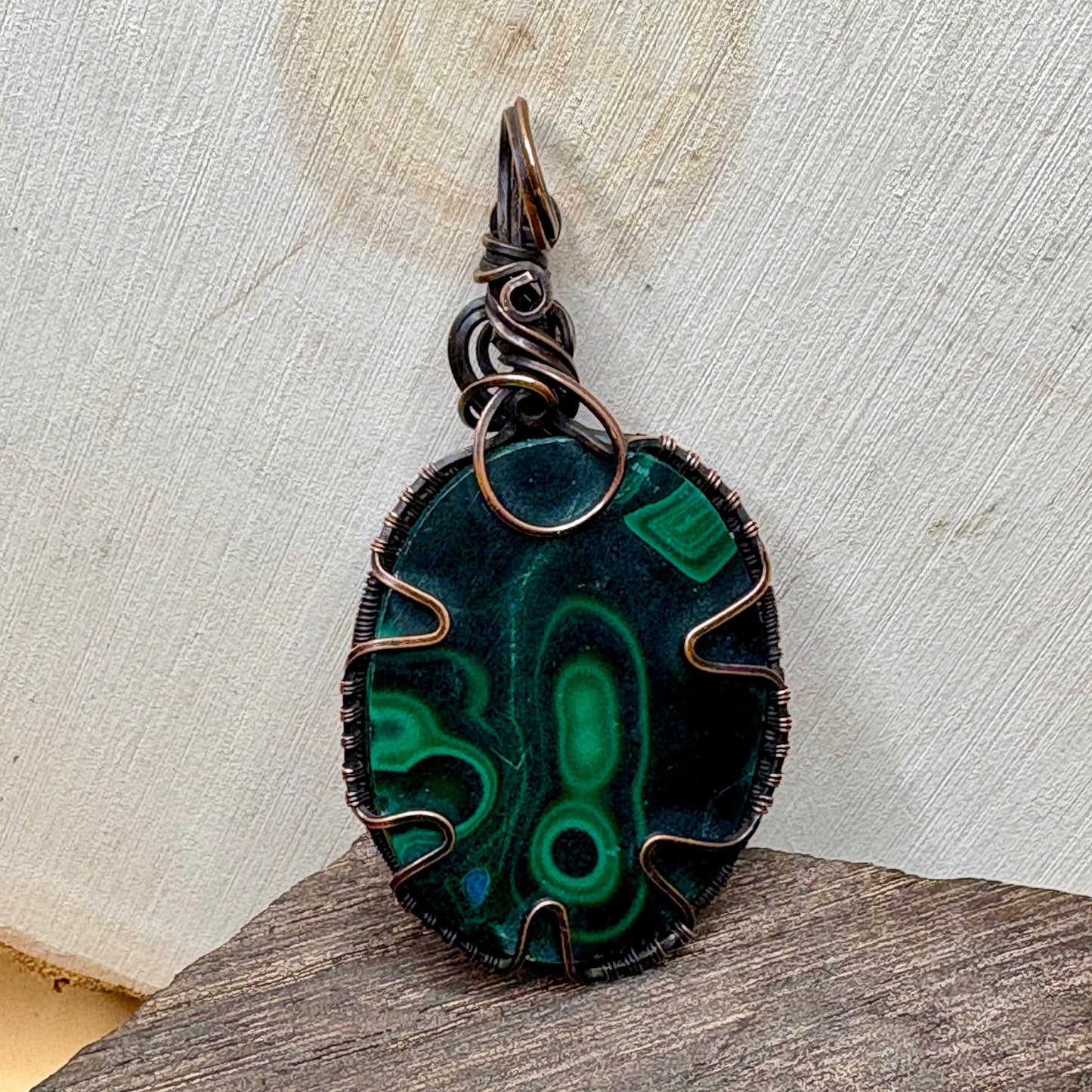 copper jewelry malachite green stone sitting on wood background