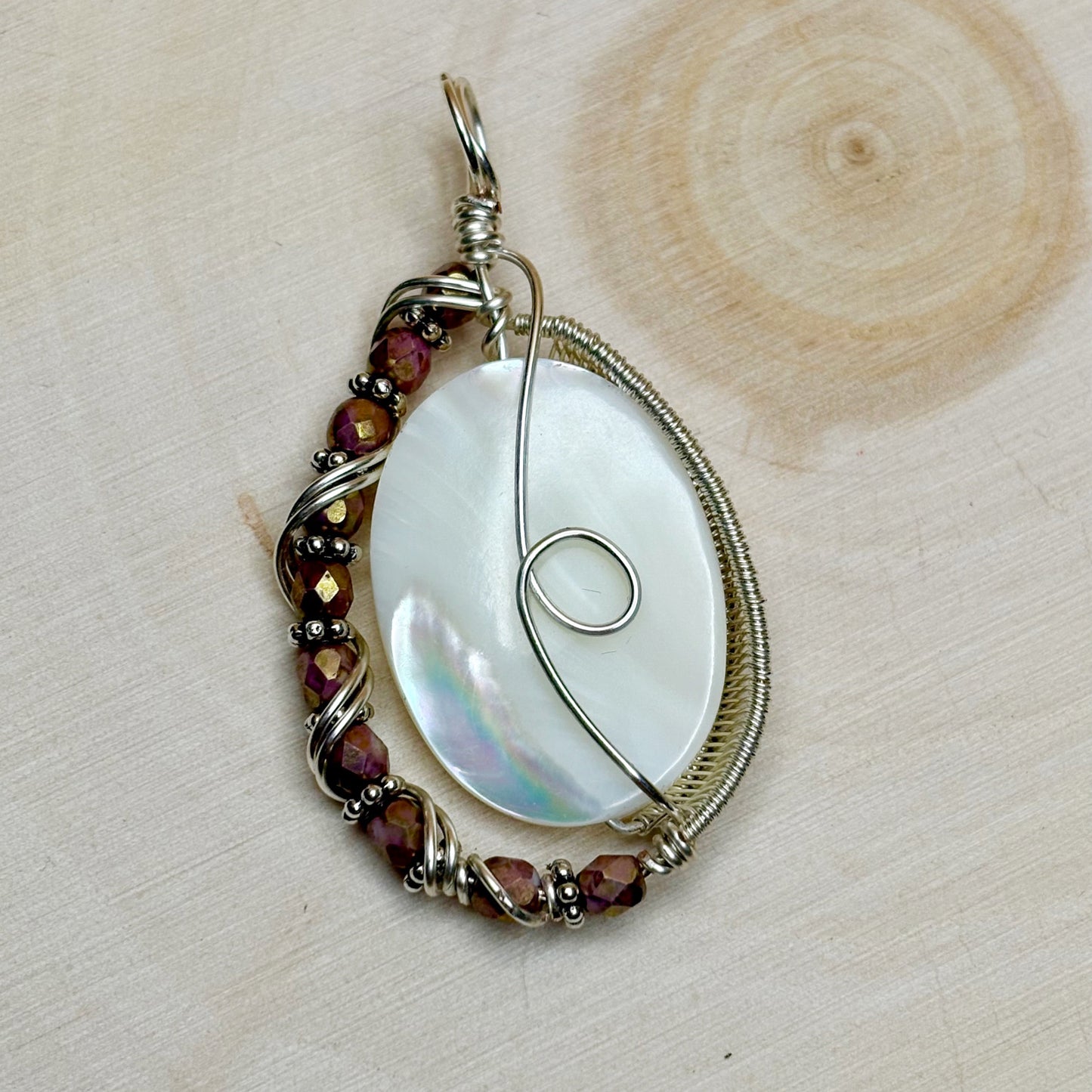 Silver wire wrap pendant featuring a mother of pearl shell