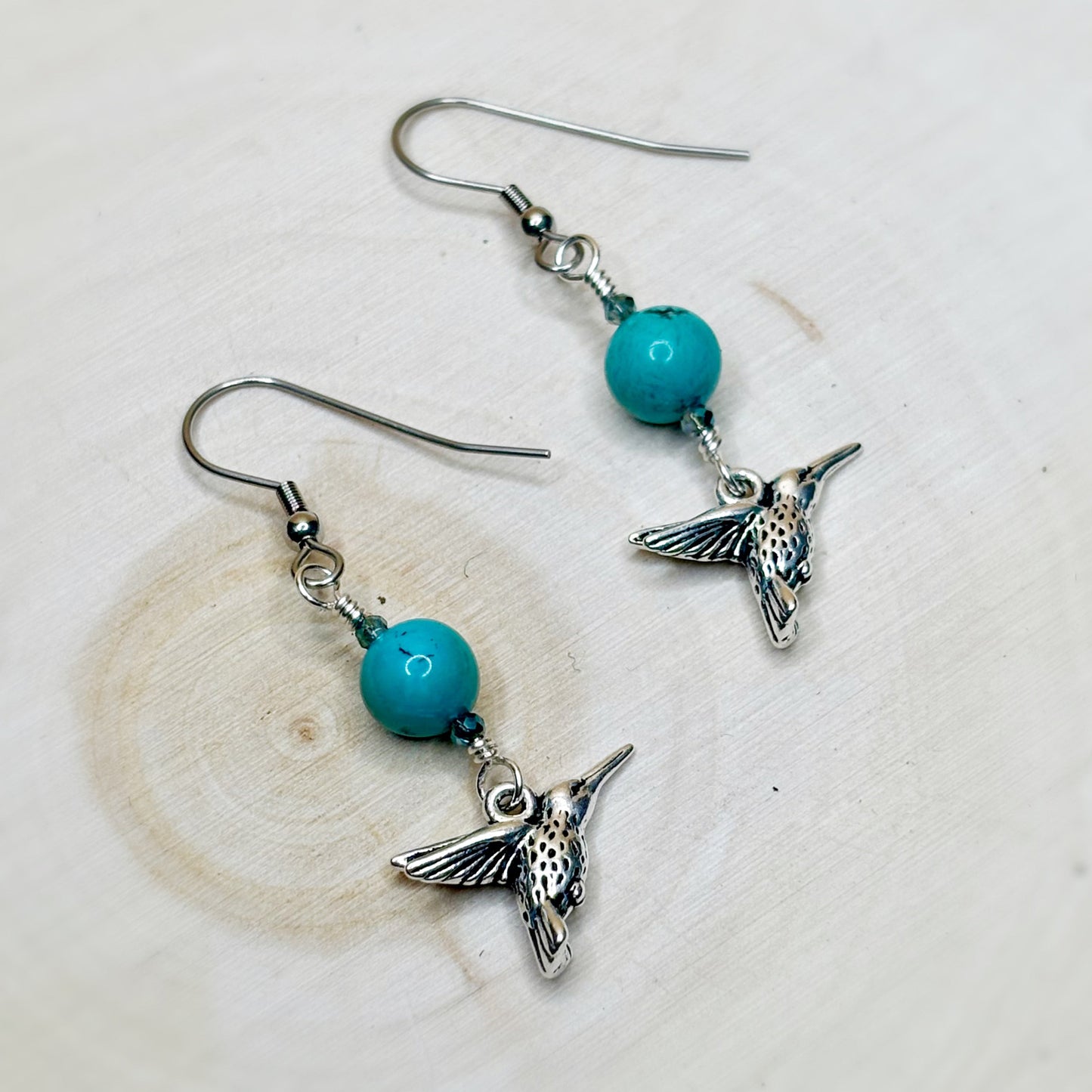 Hummingbird earrings with turquoise beads on a light background