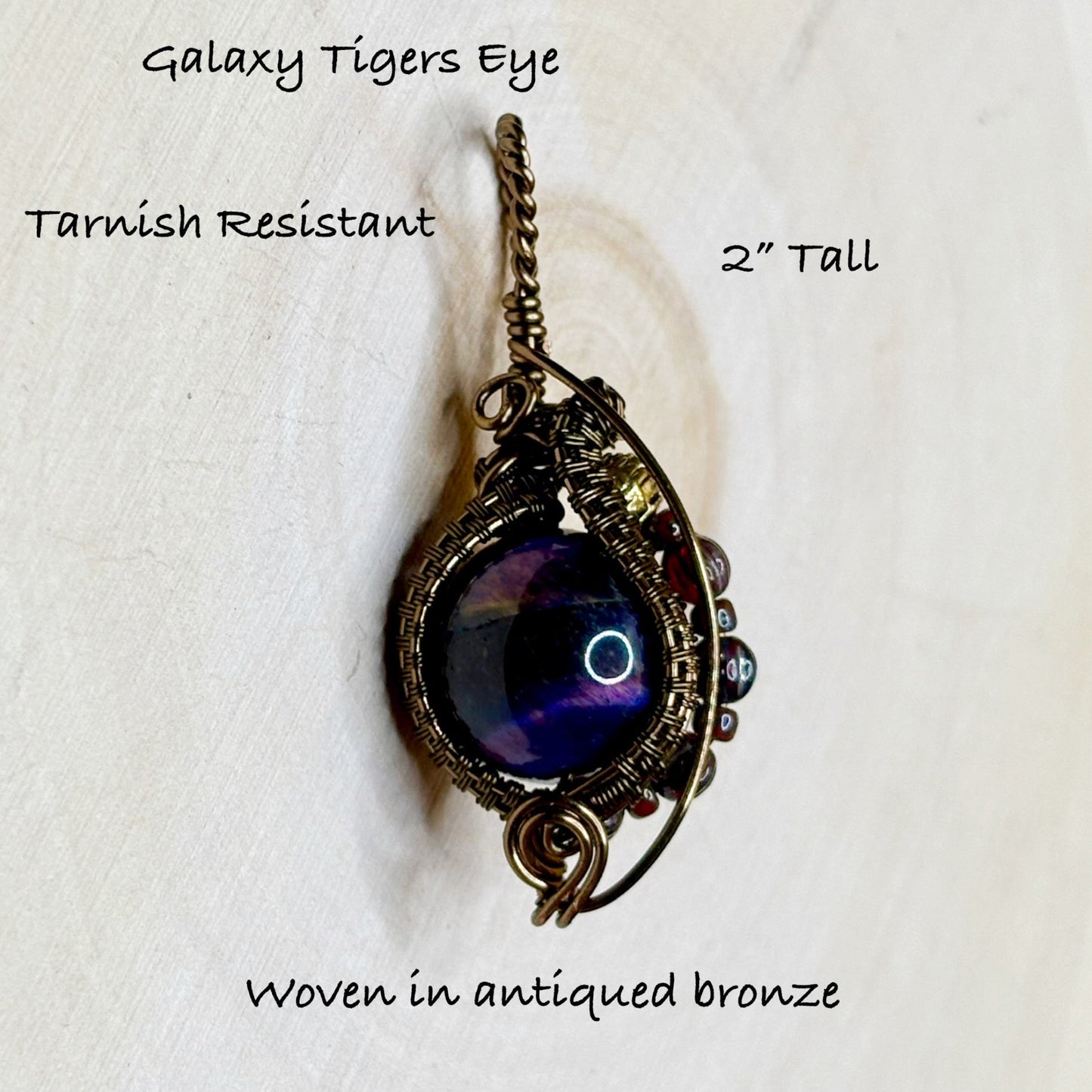 Jewelry pendant with purple stone and woven in antqique bronze on a white background