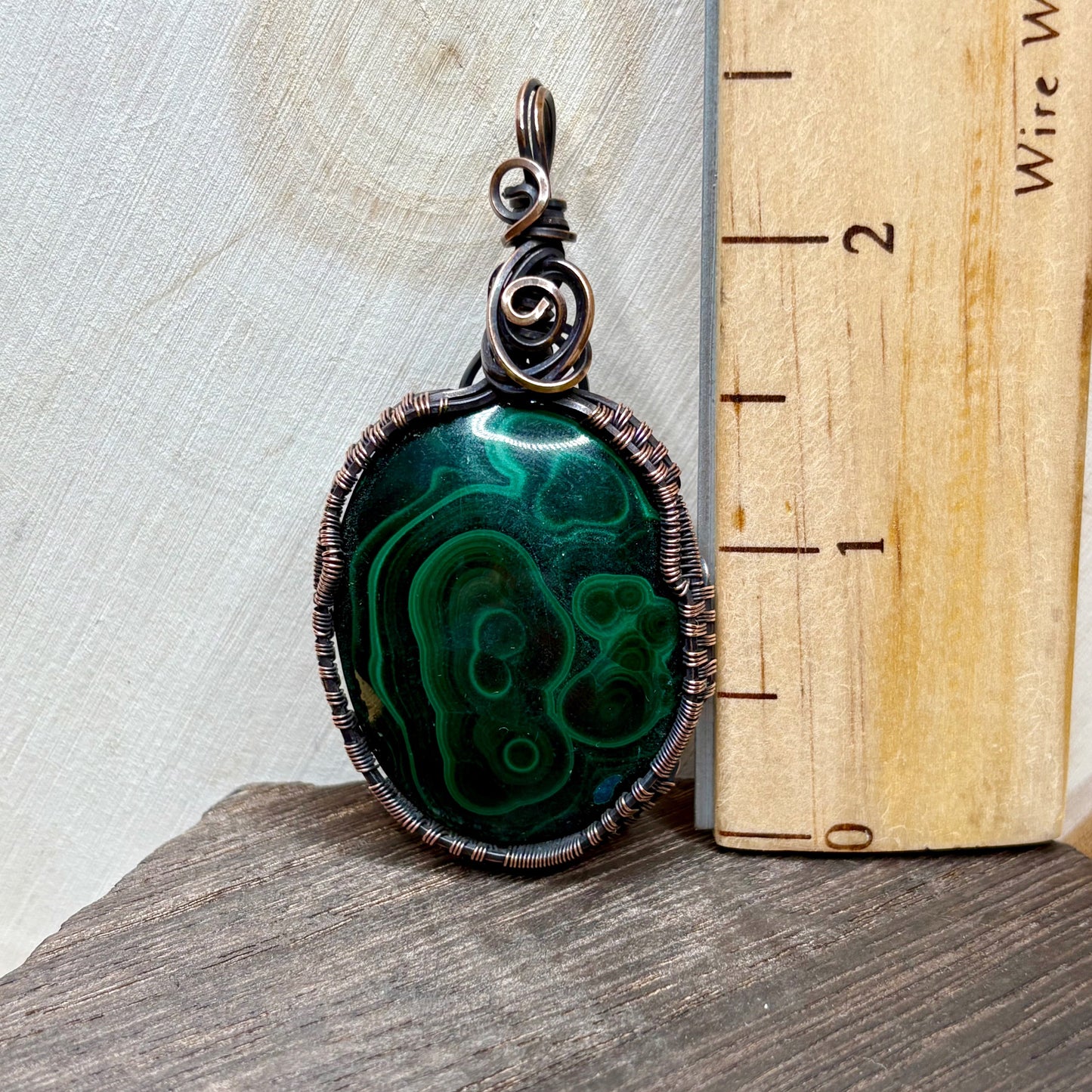 Copper jewelry with green stone on wood background