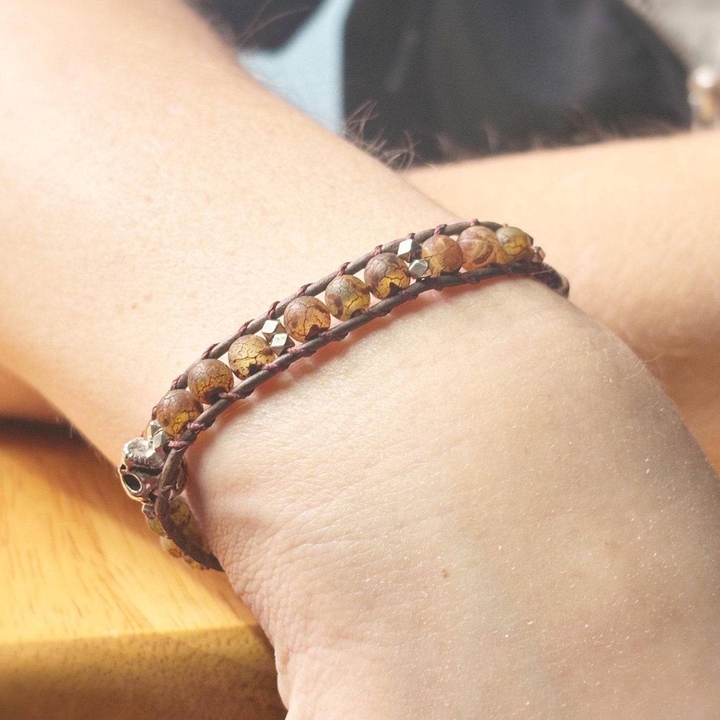 Close-up of a wrist wearing a brown beaded bracelet.