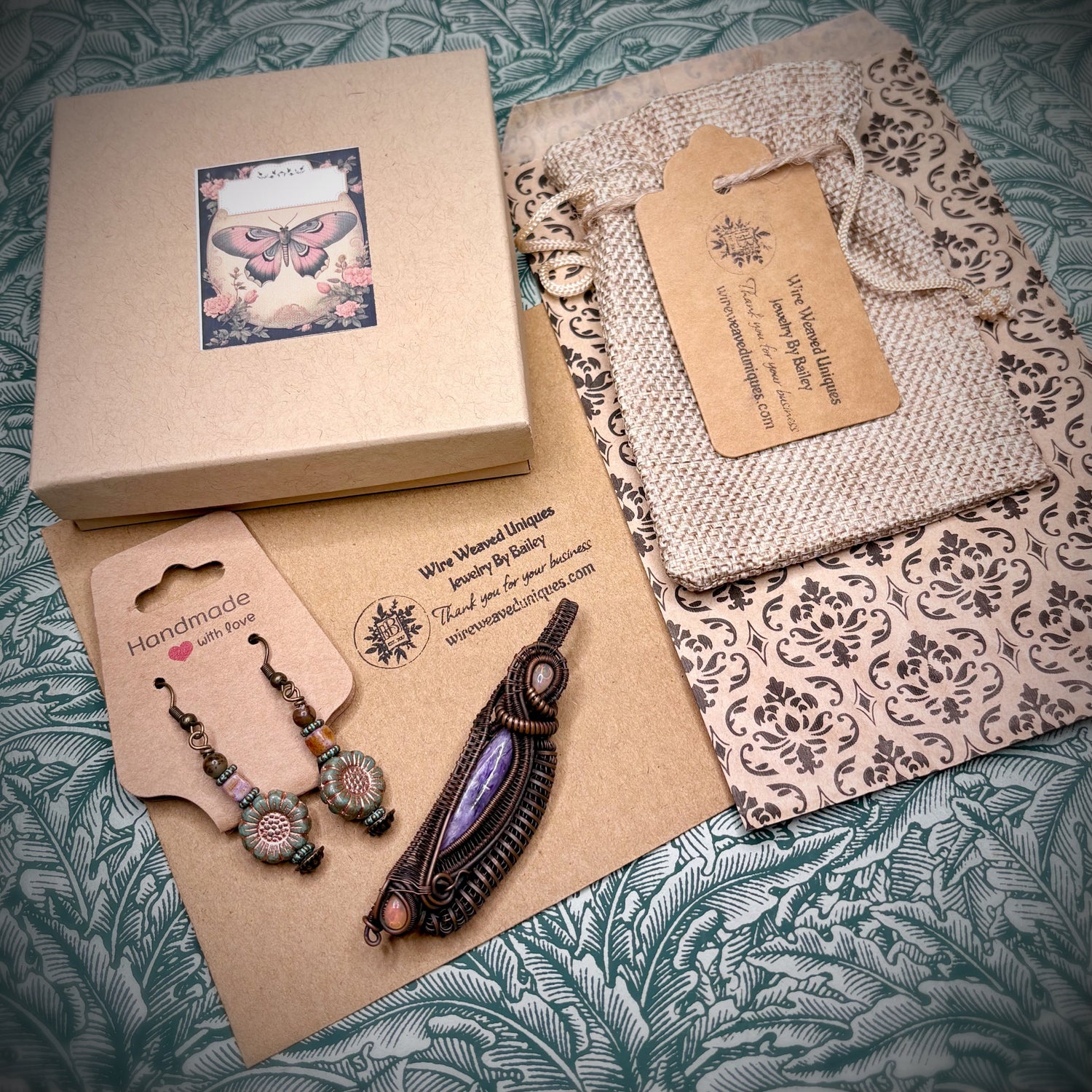 Handmade jewelry set with earrings and a pendant on a decorative surface