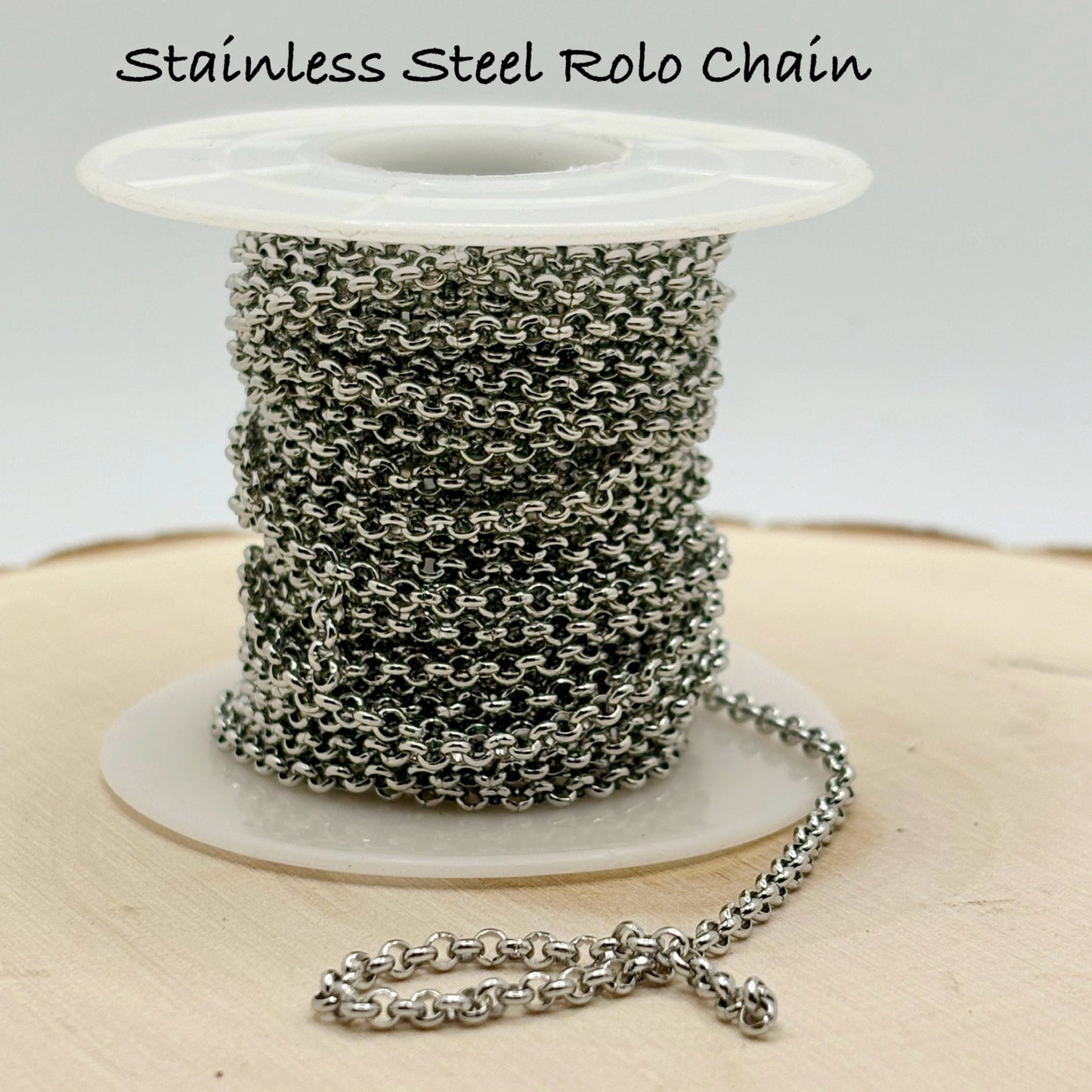Spool of stainless steel Rolo chain on a white background