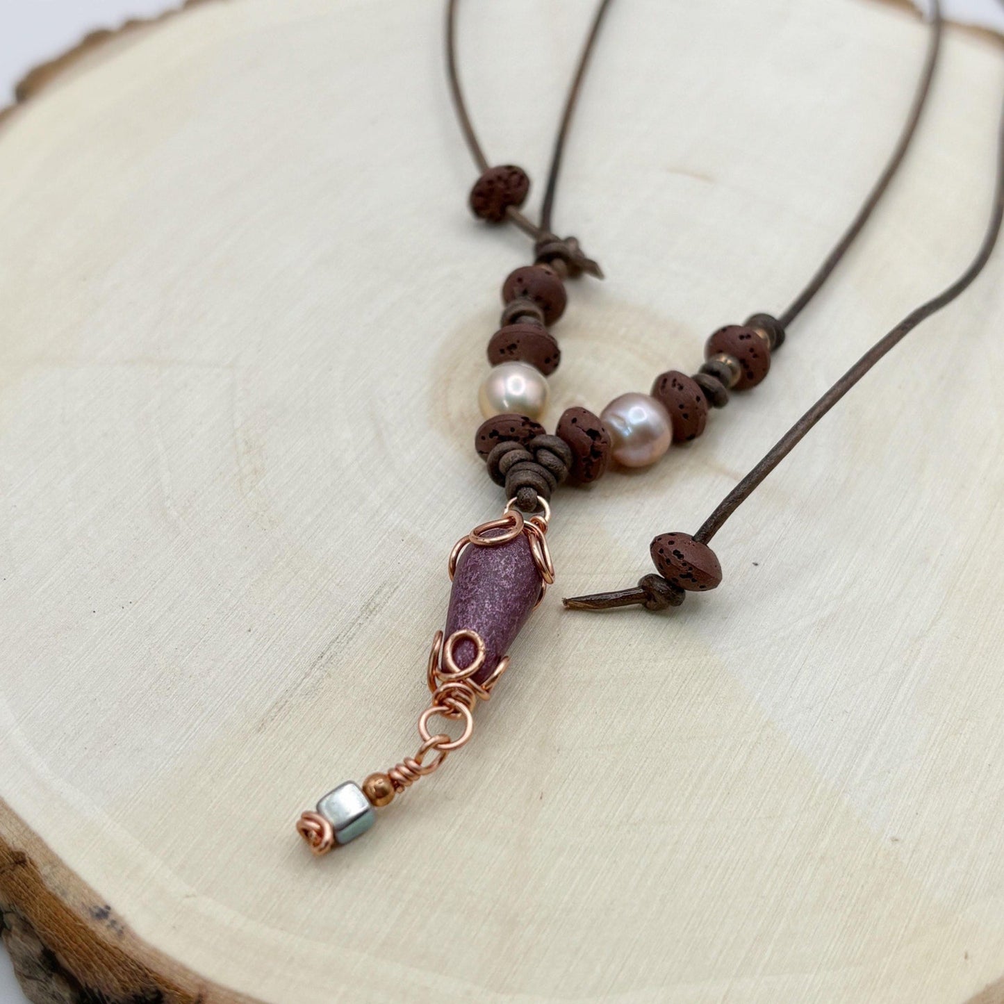 Necklace with brown beads and a copper accent on a wooden surface