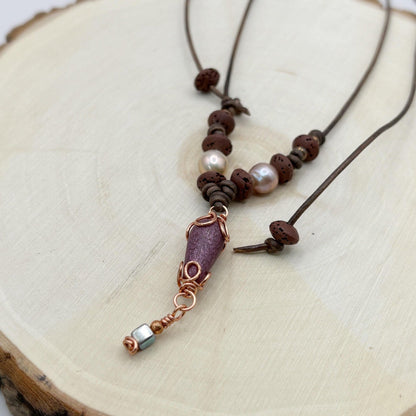 Necklace with brown beads and a copper accent on a wooden surface