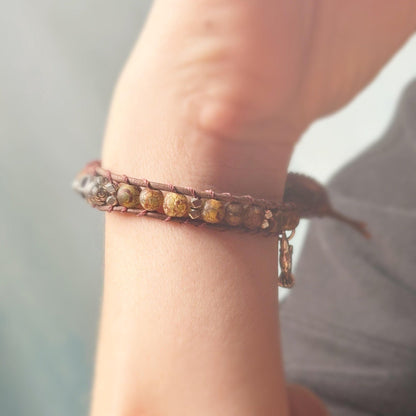 Close-up of a wrist wearing a beaded bracelet with a blurred background