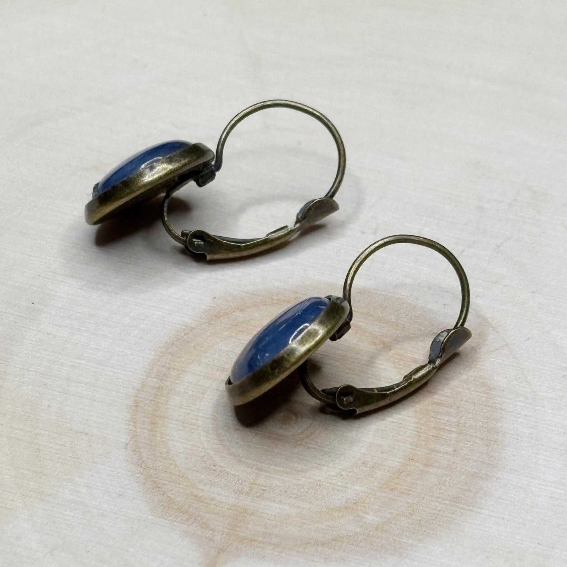 Pair of earrings with blue stones on a textured white surface