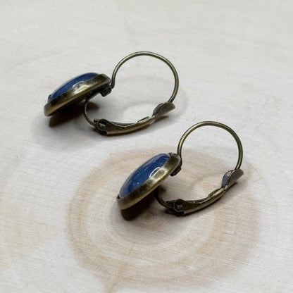 Pair of earrings with blue stones on a textured white surface