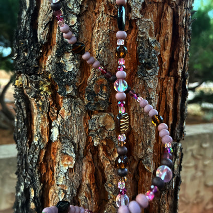 Beaded sun catcher hanging on a tree trunk