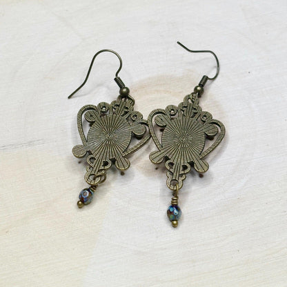 Pair of ornate bronze earrings on a light background