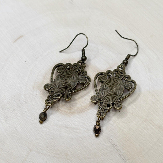 Pair of bronze-colored earrings on a white background