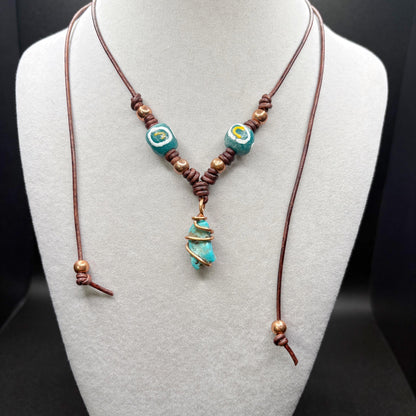 Necklace with turquoise beads and brown cord on a mannequin bust.