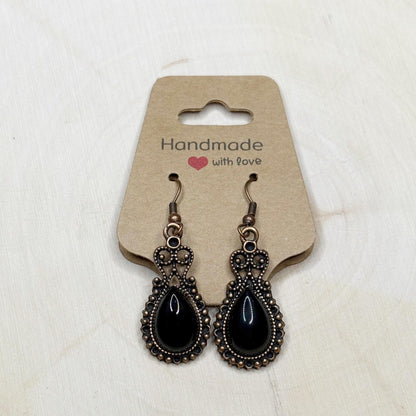 Pair of black teardrop earrings on a 'Handmade with Love' card against a white background
