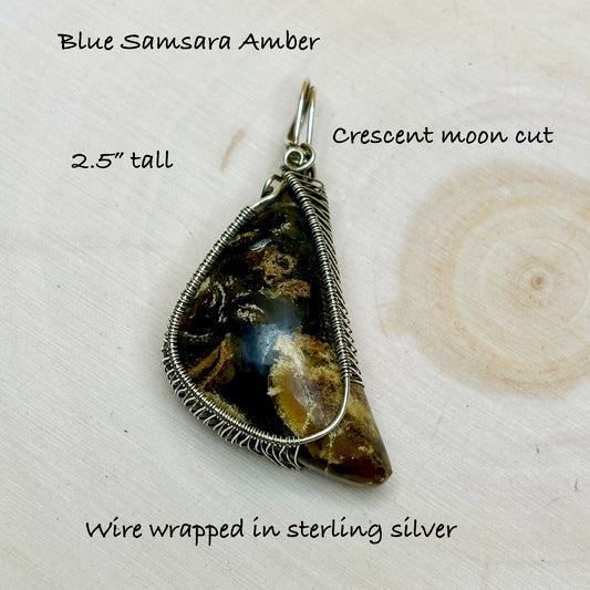 Wire-wrapped amber pendant with text on a light background