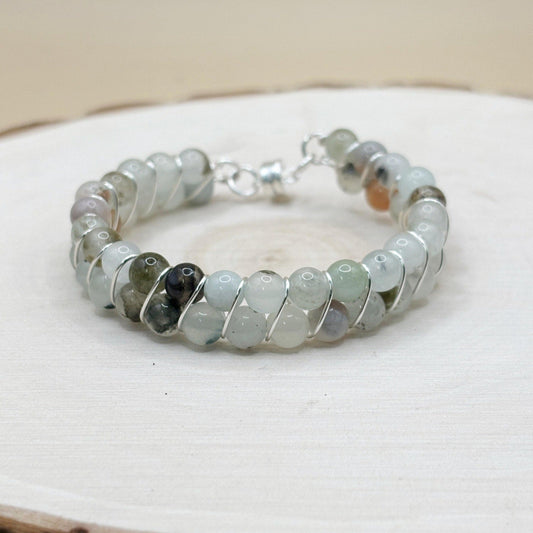 Beaded bracelet with silver accents on a white wooden surface-p