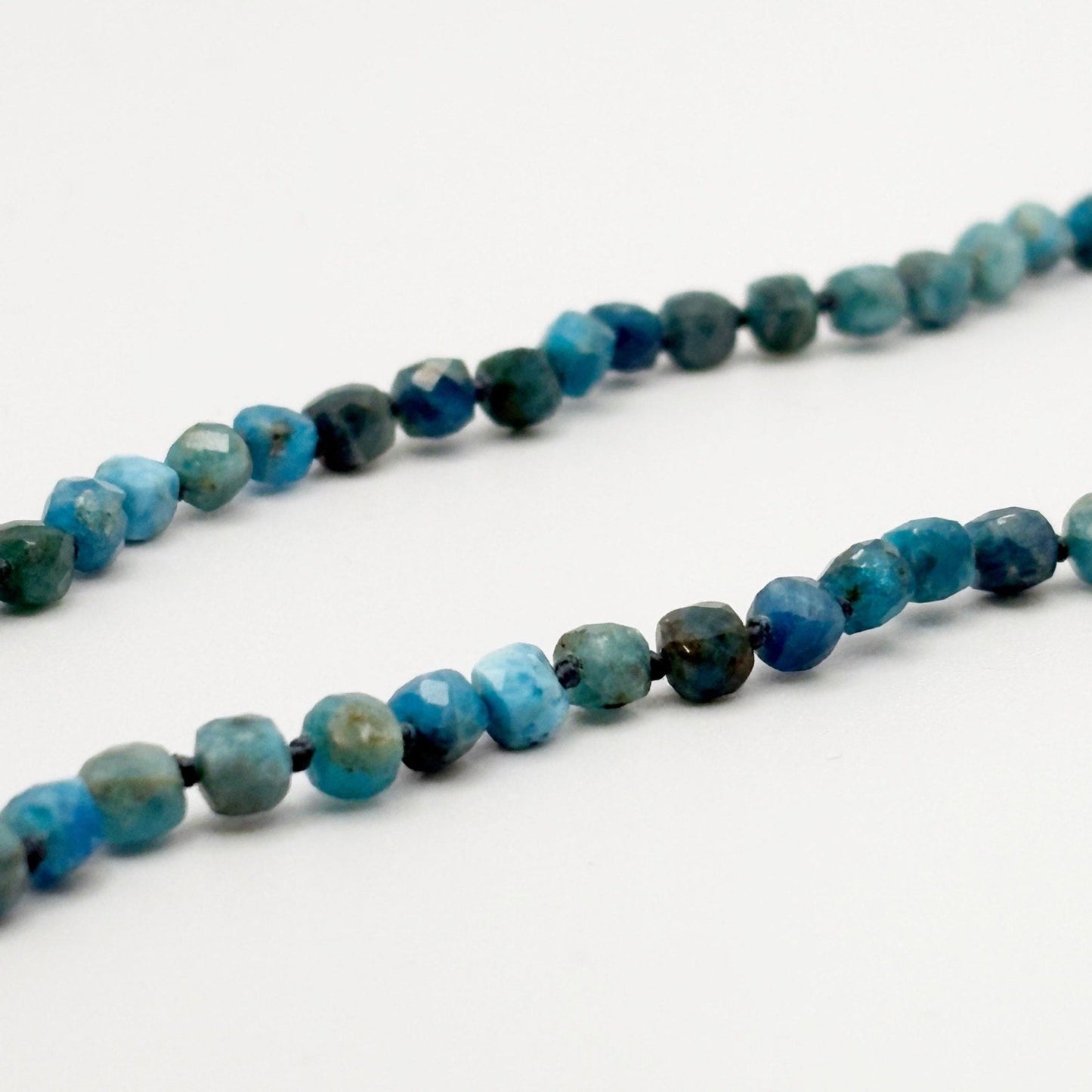 Necklace with blue and green beaded stones on a white background