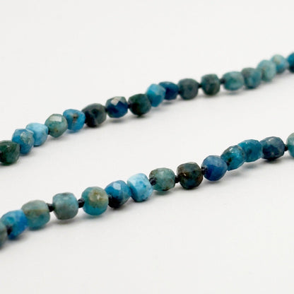 Necklace with blue and green beaded stones on a white background