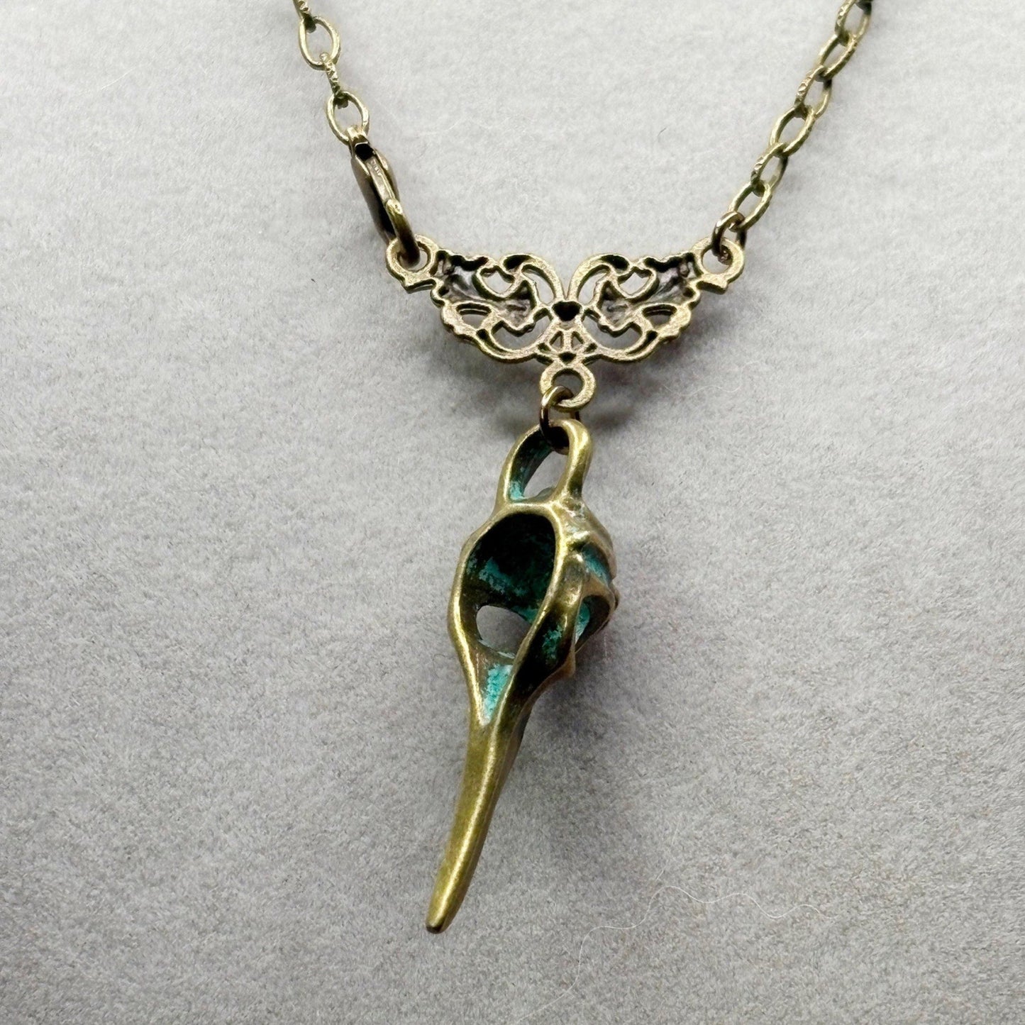 Bronze and green pendant necklace on a light gray background