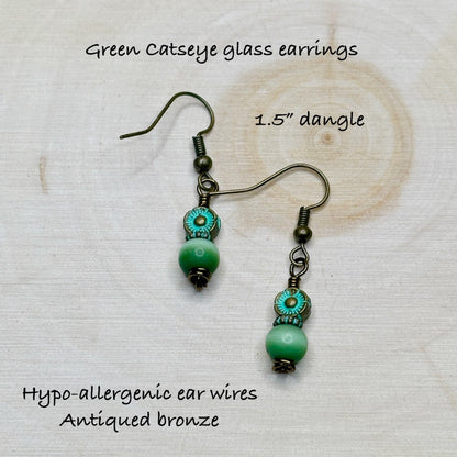 Green catseye glass earrings with hypo-allergenic ear wires on a textured white background