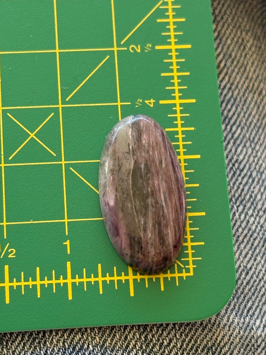 Oval-shaped stone on a green cutting mat with yellow measurements