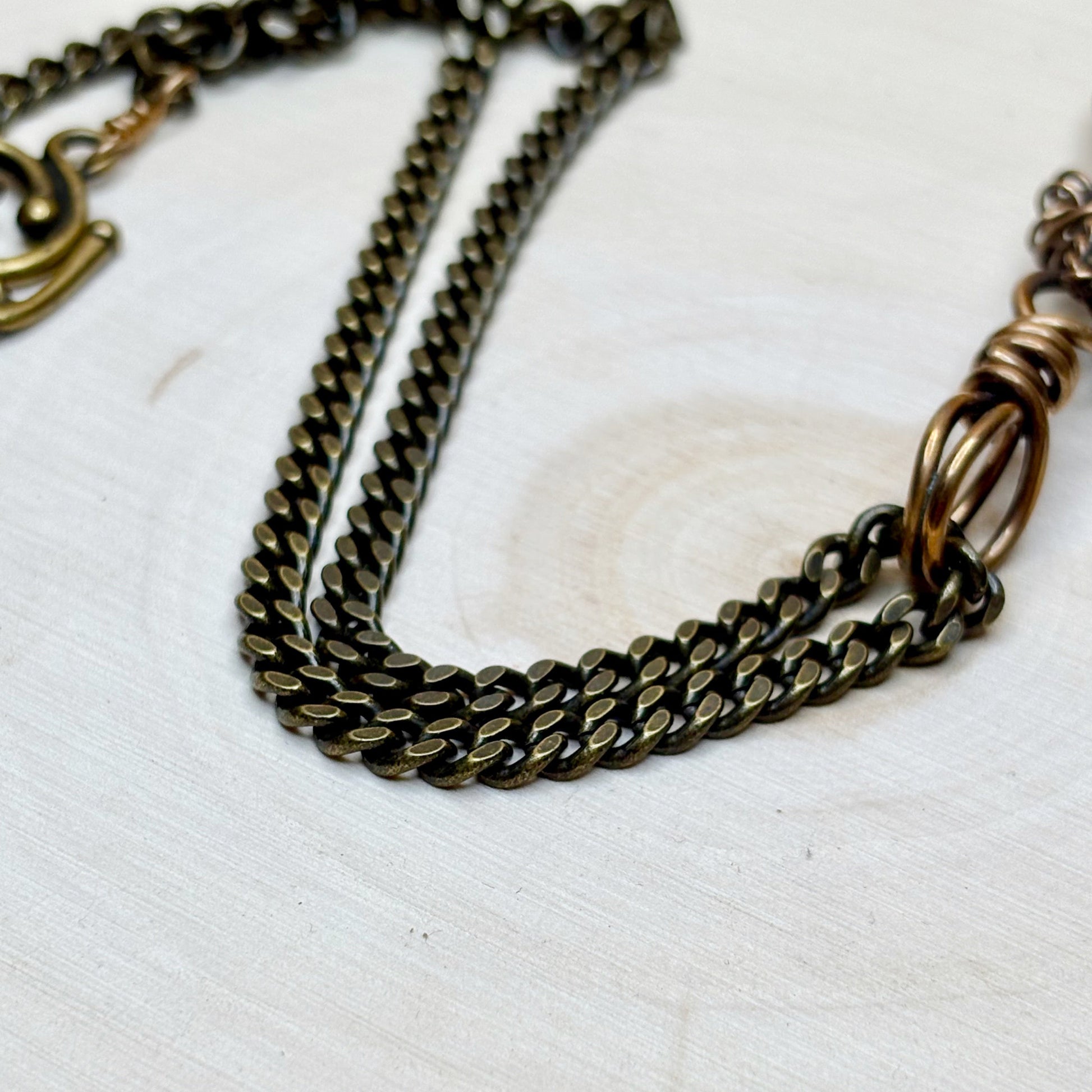 Bronze chain necklace on a white textured surface
