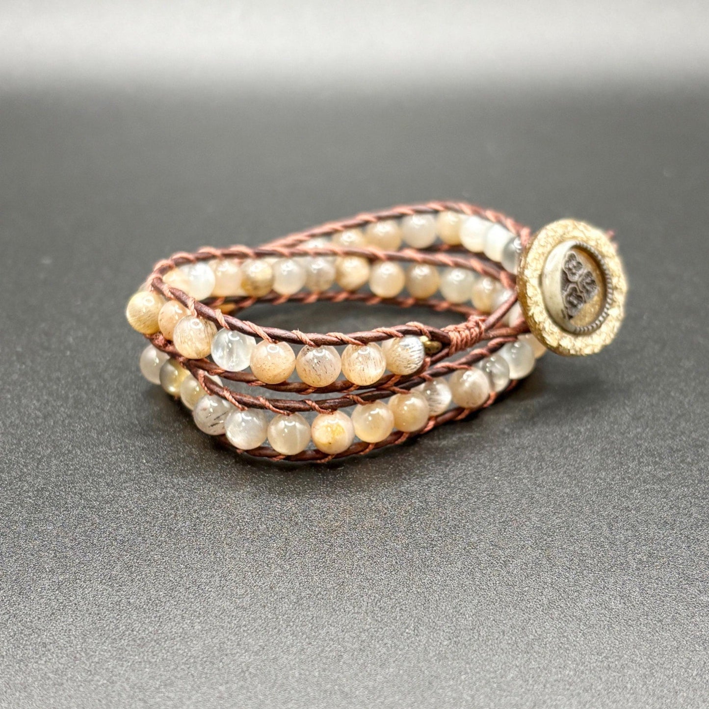 Multistrand beaded bracelet with a bone clasp on a gray background