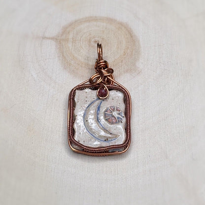 Copper-framed pendant with a textured center on a light fabric background