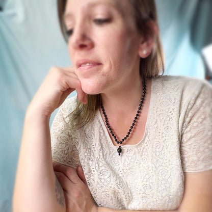 Woman wearing a necklace with a blurred background