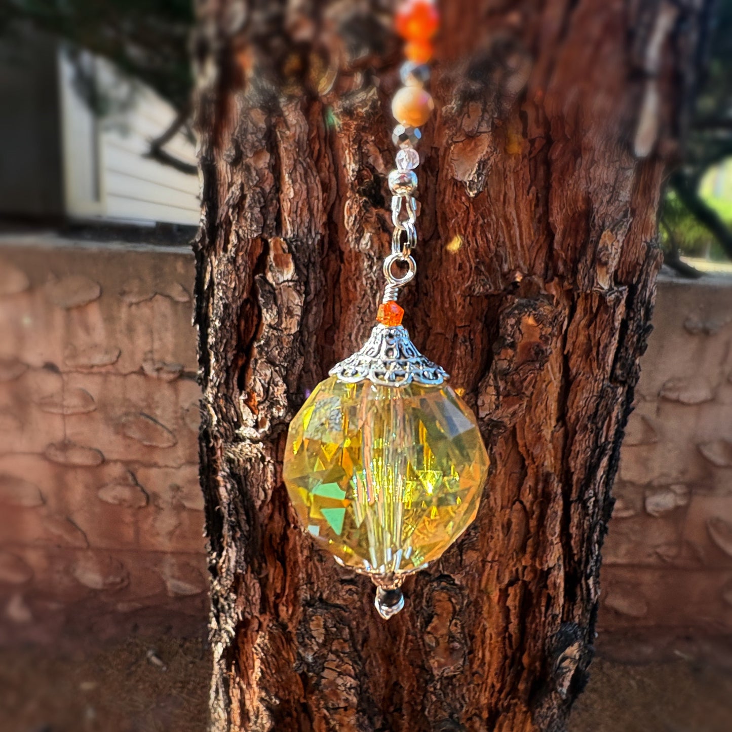 Decorative yellow glass focal hanging from a sun catcher 