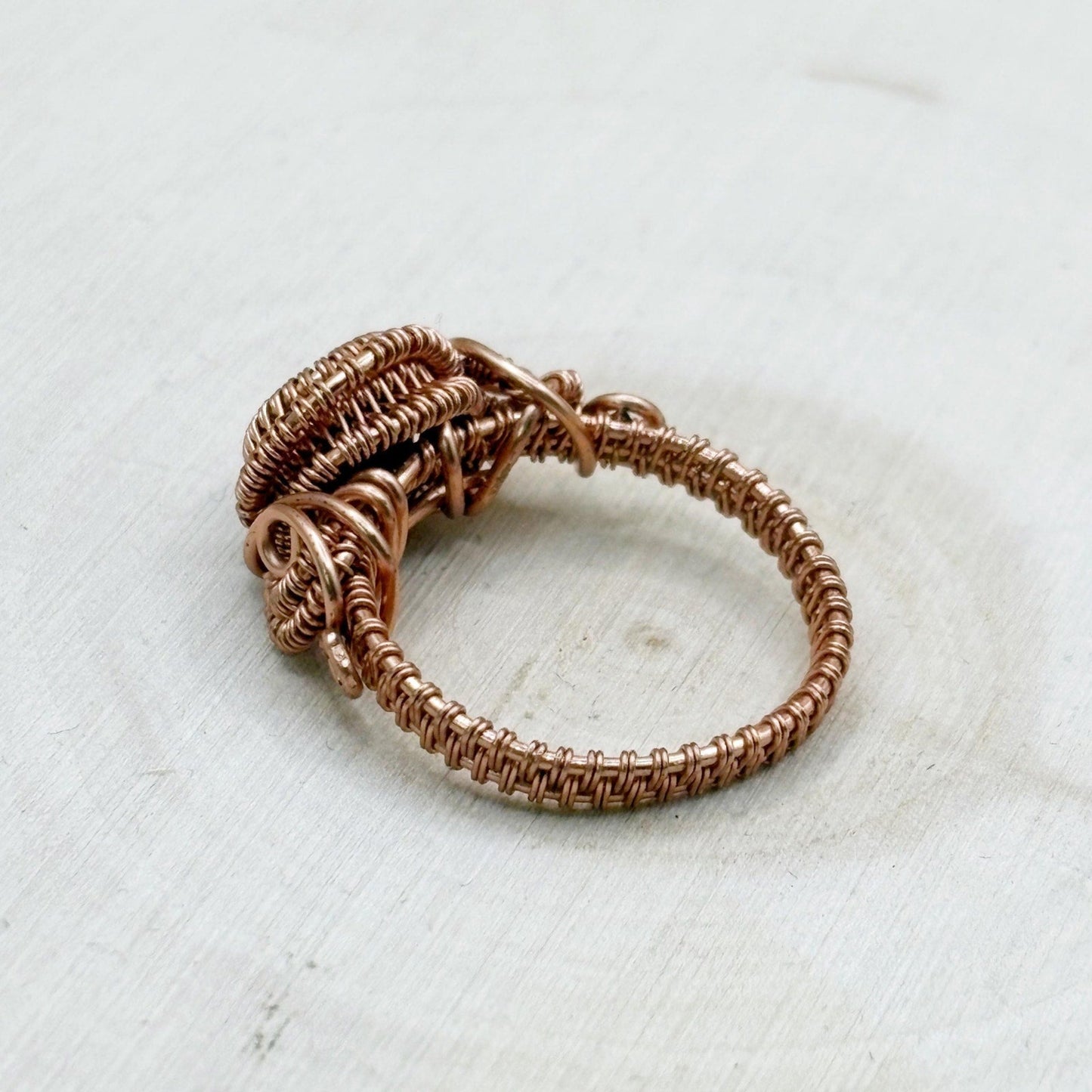Copper wire ring on a textured white surface