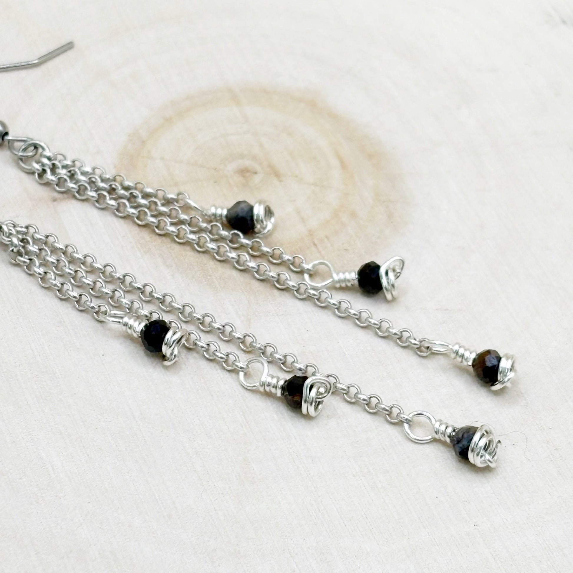 Silver chain necklace with blue beads on a white background