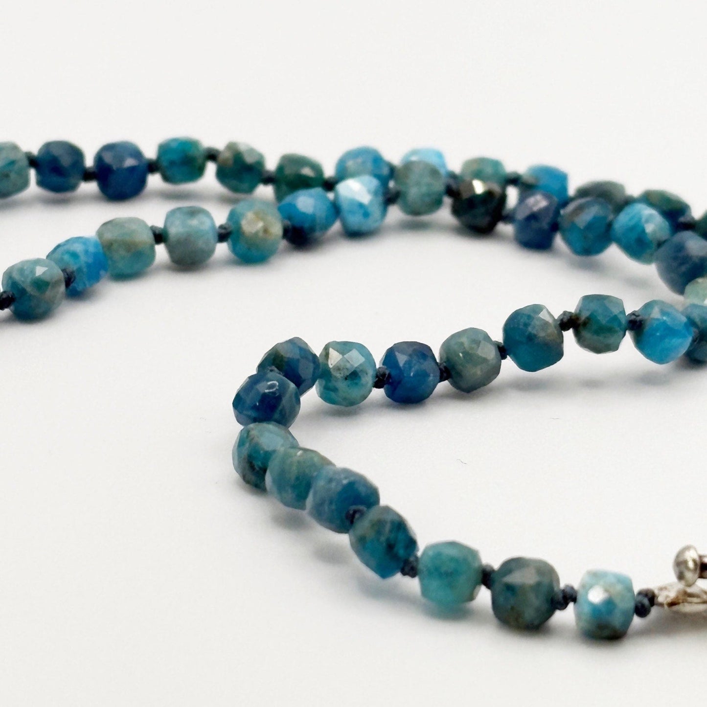 Necklace with blue knotted chain on a white background