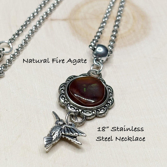 Necklace with natural fire agate pendant and bird charm on a light background