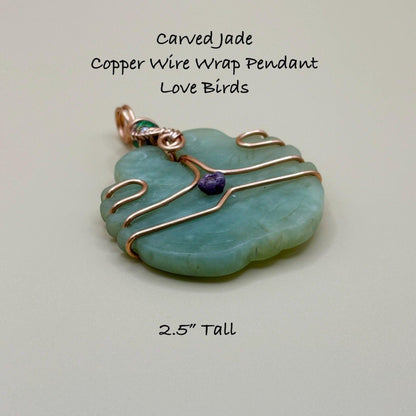 Carved jade pendant with copper wire wrap on a light gray background