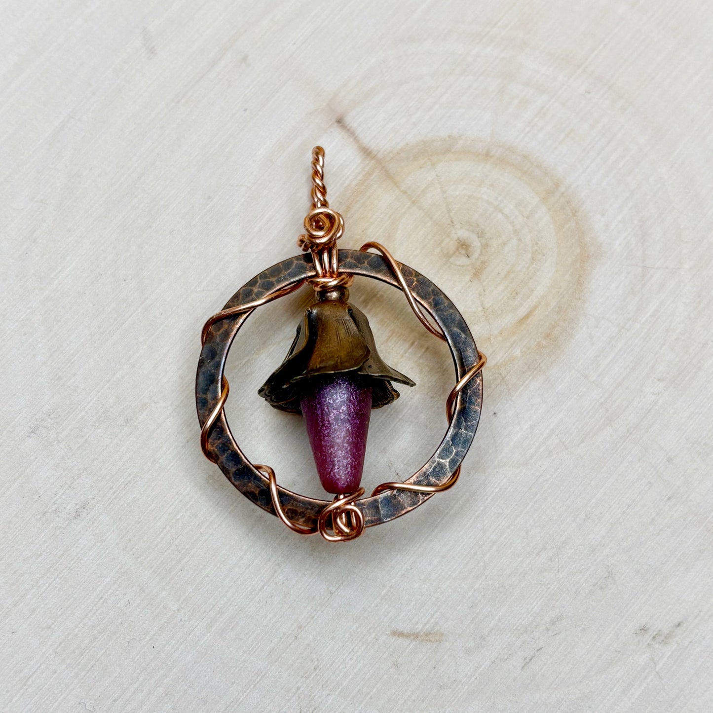 Copper pendant with a Czech glass drop on a textured white background