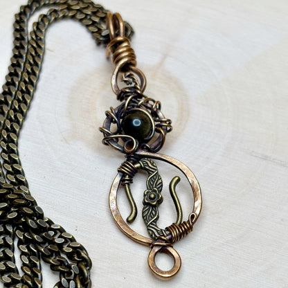 Bronze necklace with intricate pendant on a white background