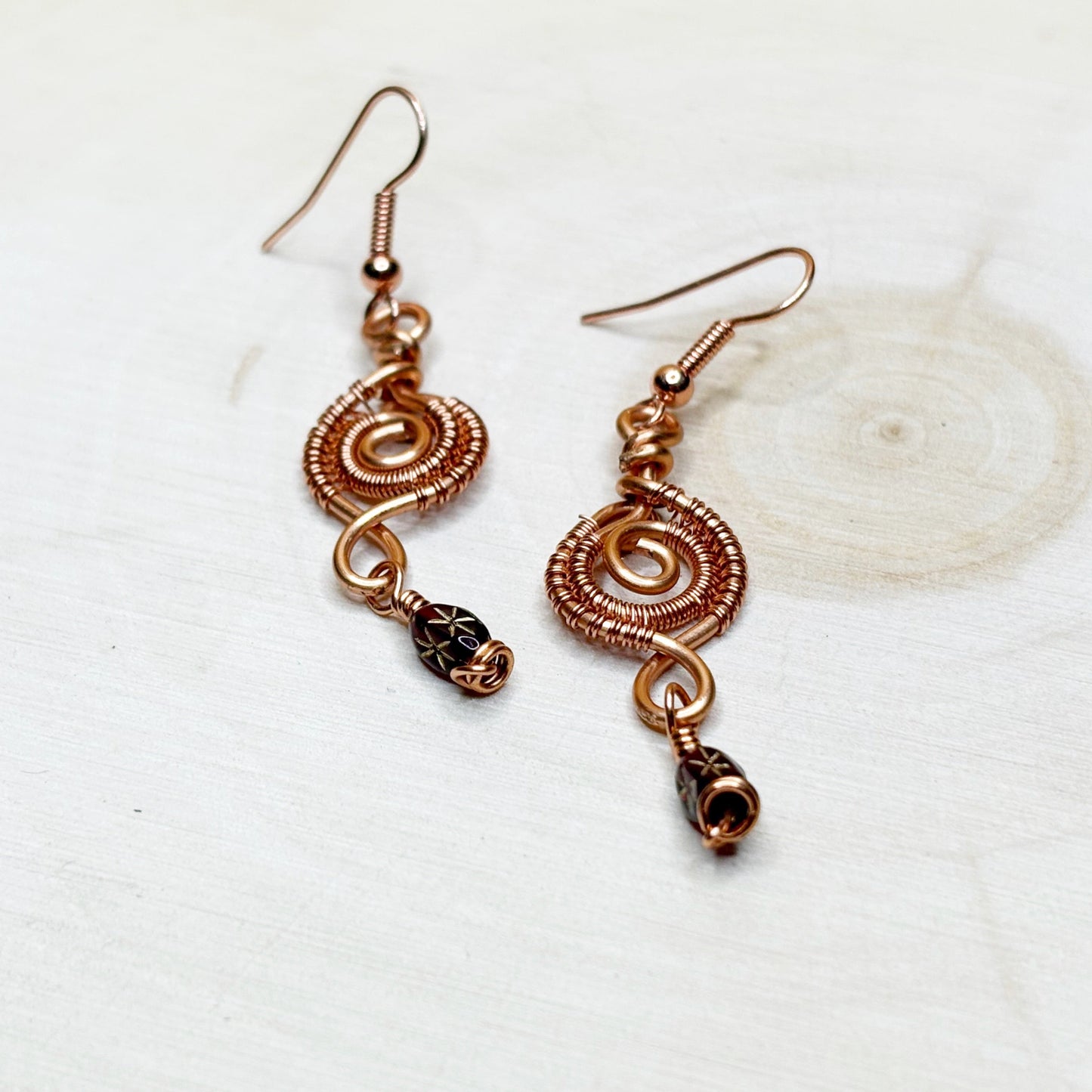 Copper wire-wrapped earrings on a white background