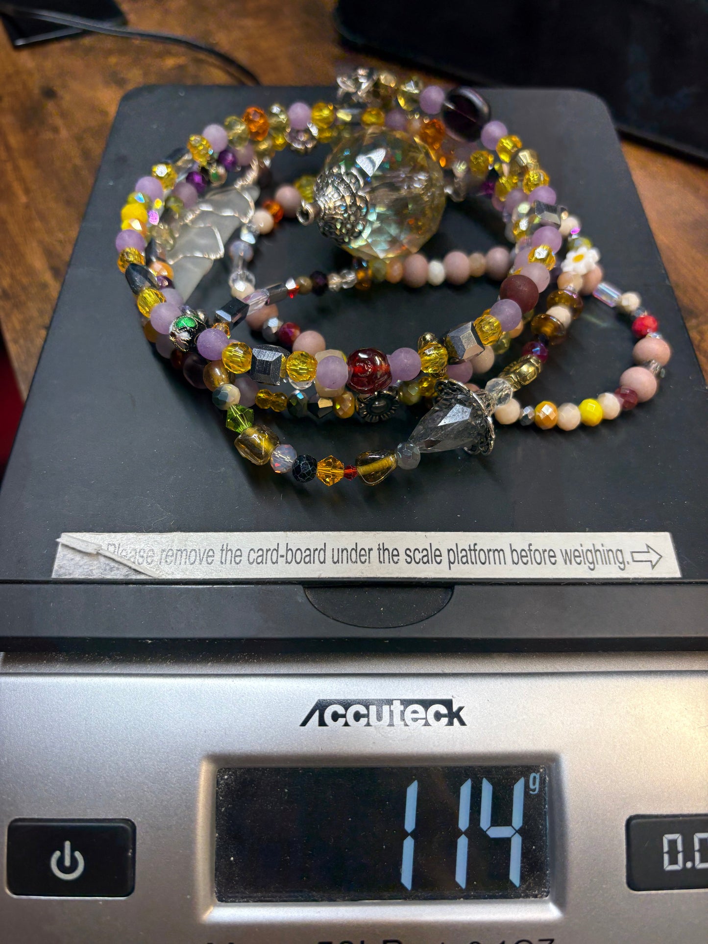 Colorful beaded sun catcher on a digital scale displaying weight