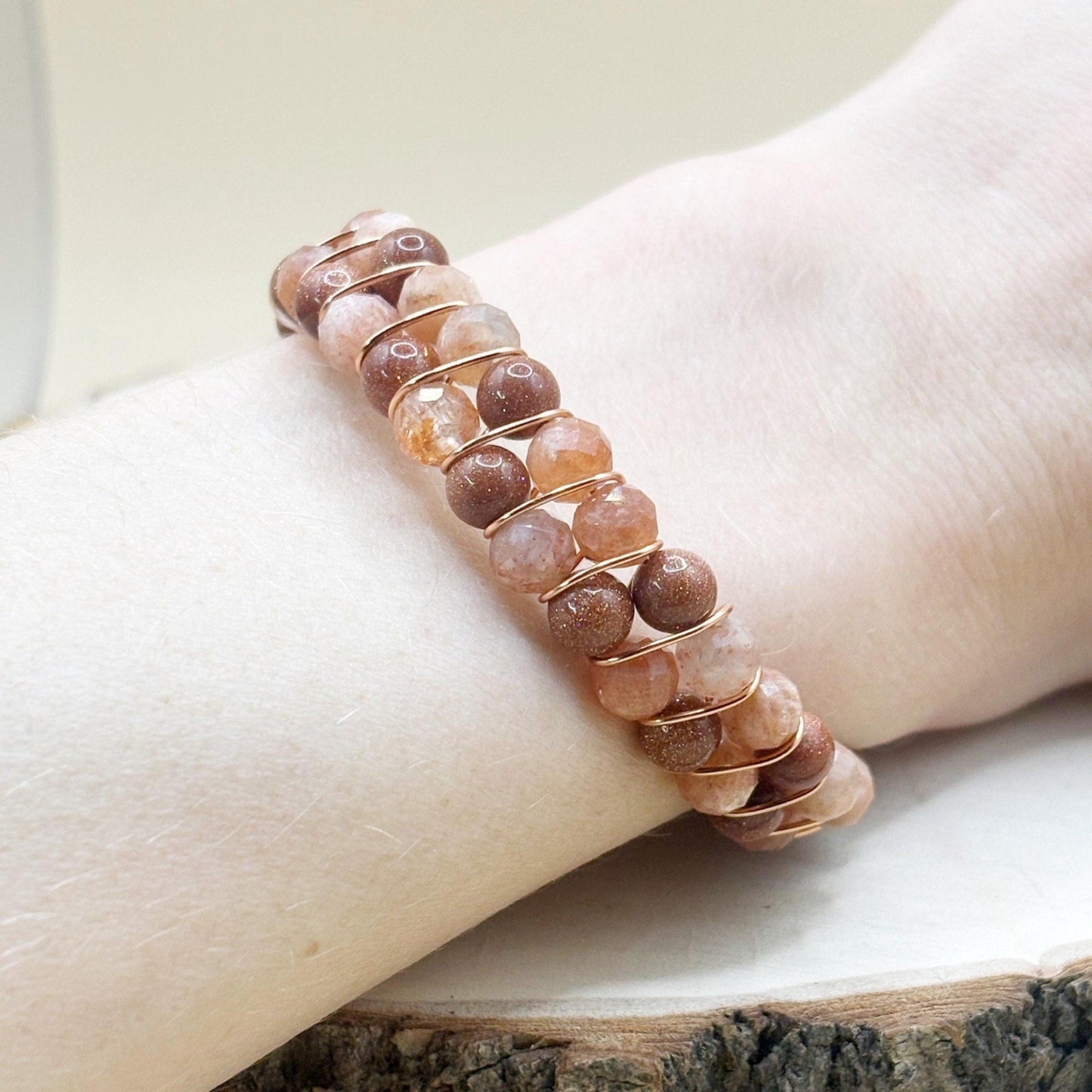 Beaded bracelet on a wrist with a neutral background