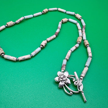 Necklace with floral pendant on a green background