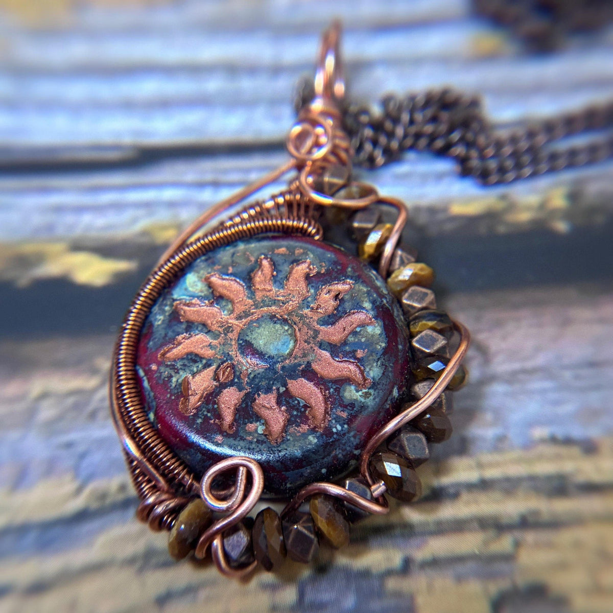 closeup of copper wire wrap pendant showing brown shimmering tigers eye beads and copper wire wrapping