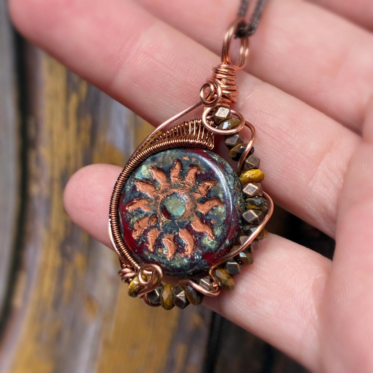 Hand holding tigers eye pendant