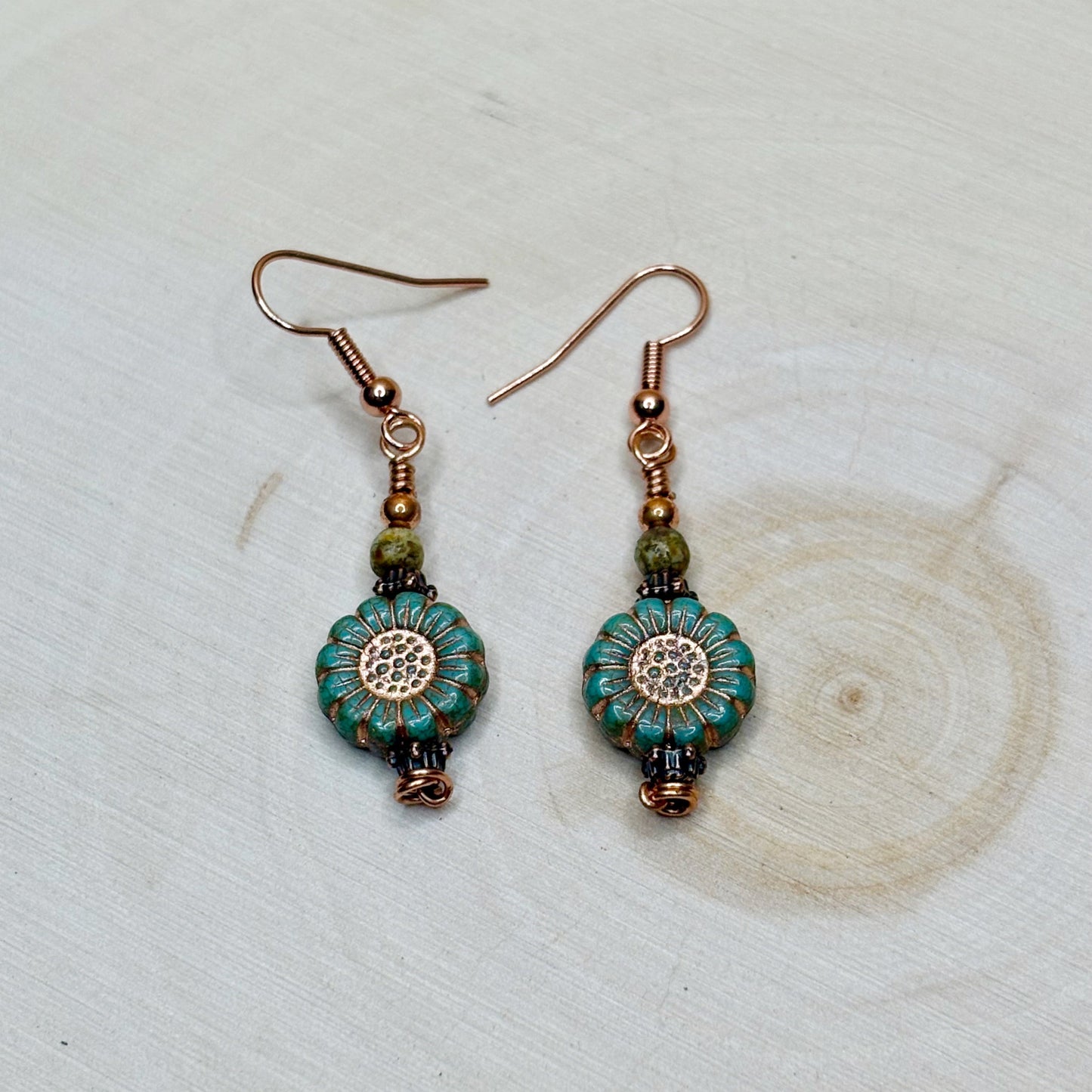 Copper jewelry earrings with flowers on a wooden background