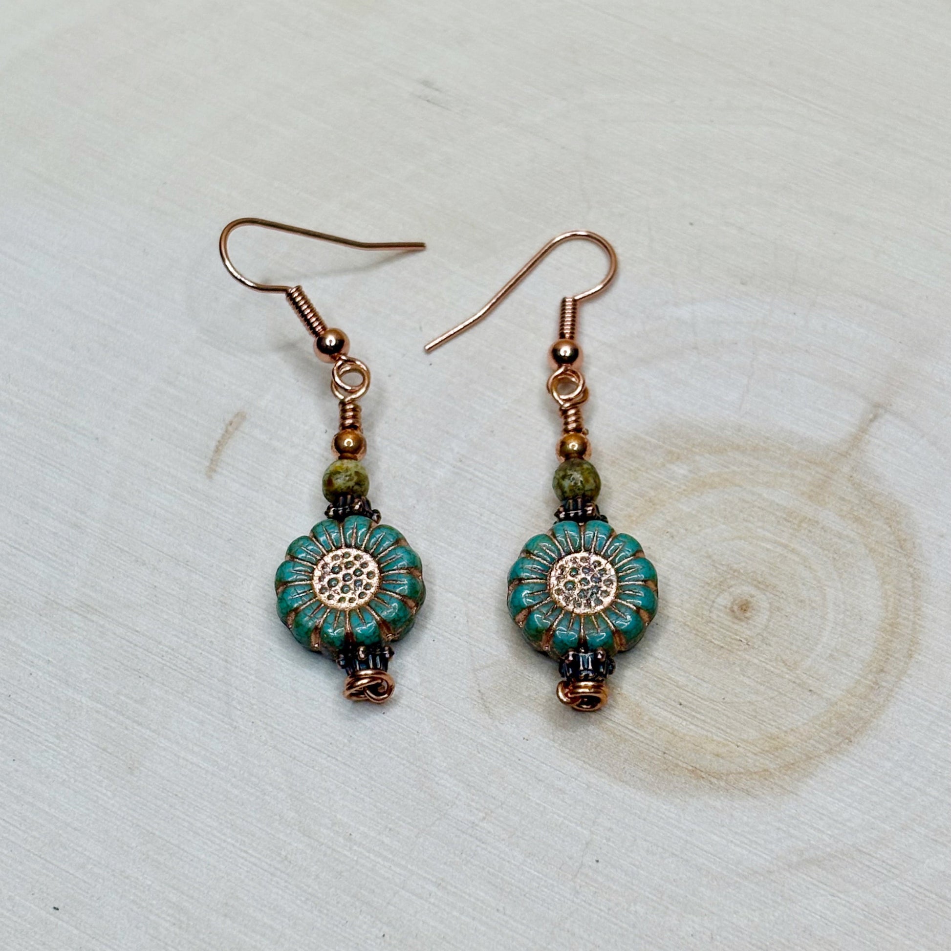 Copper jewelry earrings with flowers on a wooden background
